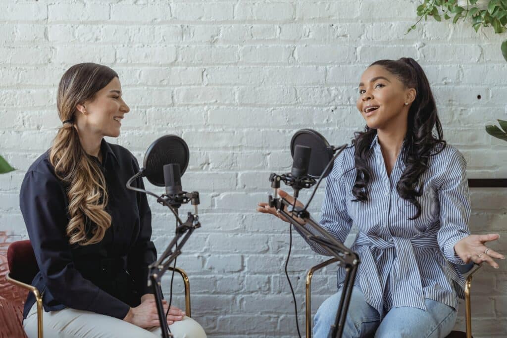 Two females speaking into mics